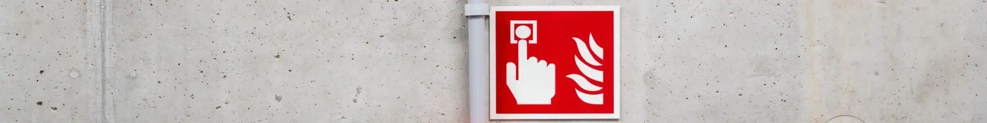 A bright red emergency button and alarm sign mounted on a wall, indicating a safety alert for emergencies, accessible for quick response, ideal for public and workplace safety signage.