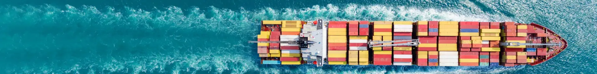 An aerial view of a large cargo ship filled with colorful containers sailing through the ocean, symbolizing international trade, shipping logistics, and maritime freight services.