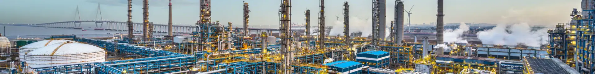 Industrial factory with pipes, smokestacks, and chemical processing equipment with emissions, illustrating manufacturing and industrial operations.