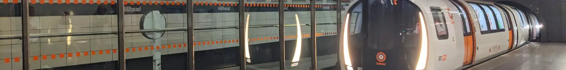 An image of a sleek, modern metro train arriving at an underground station, illuminated by stylish lighting, with reflective glass and urban ambiance, showcasing advanced public transportation infrastructure.