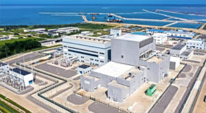 Aerial view of Weihai Nuclear Power Plant showcasing large reactors and infrastructure near the coastline.