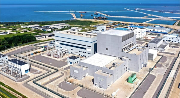 Aerial view of Weihai Nuclear Power Plant showcasing large reactors and infrastructure near the coastline.