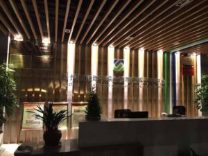 Interior view of the Suzhou Chengbei Road Integrated Pipeline Project office, showcasing modern design with wooden accents, lighting, and reception area.