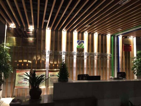 Interior view of the Suzhou Chengbei Road Integrated Pipeline Project office, showcasing modern design with wooden accents, lighting, and reception area.