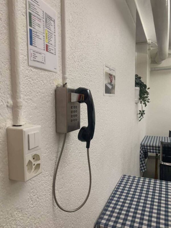 Communication system with a wall-mounted telephone and control panel at a hotel in Switzerland.
