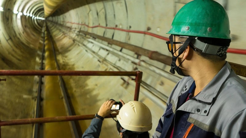 two worker inspecting a power tunnel