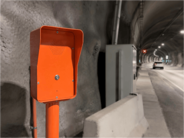Orange emergency telephone station installed inside a road tunnel for safety communication in Norway.